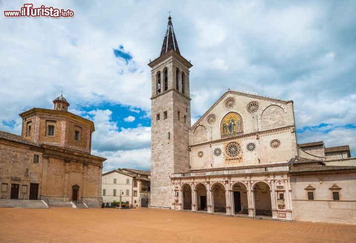 Immagine Piazza Duomo nel centro di Spoleto, Umbria. La sua forma rettangolare che culmina con una lunga scalea la rende una delle piazze più caratteristiche d'Italia. Dominata a est dal colle su cui sorge la Rocca, questa piazza ospita il duomo con la sua facciata rosata, il battistero, il teatro Caio Melisso e la Casa dell'Opera del Duomo - © javarman / Shutterstock.com