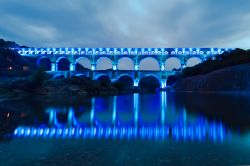 Acquedotto romano a Vers, nella Linguadoca Rossiglione: il Pont du Gard viene illuminato con delle luci colorate - © Matej Kastelic / Shutterstock.com