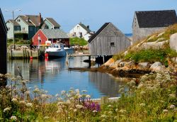 La Baia di Peggy's Cove, in Nuova Scozia (Canada), e i suoi colori accesi: il blu del mare e del cielo contratano con le tinte neutre del legno e con le pareti variopinte di alcune case ...