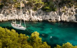 Una barca e turisti in un fiordo de Les Calanques, area protetta vicino a Cassis, in Francia - foto © Filip Stoklas / Shutterstock.com