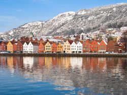 Il quartiere Bryggen, patrimonio dell'UNESCO a Bergen (Norvegia), fotografato con la neve in inverno, in una rara giornata di sole - © Thomas Skjaeveland / Shutterstock.com