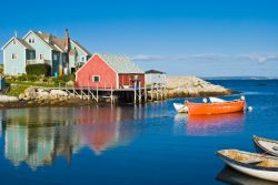 Le case colorate di Peggy's Cove (Nuova Scozia, Canada) si specchiano a testa in giù nel blu acceso del mare. Il legno è il materiale da costruzione per eccellenza, non solo ...
