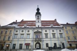 Neve nel centro storico di Maribor, Slovenia - Su Glavni trg, la principale piazza di Maribor, si affaccia il Palazzo Comunale della città con la sua caratteristica torre dell'orologio. ...