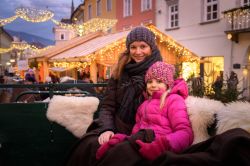 Mamma e figlia su una carrozza trainata da cavalli a Villach, Austria, durante le festività natalizie © Hannes Pacheiner