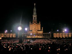 Fatima, Portogallo: veglia di preghiera sul sagrato del Santuario: i fedeli tengono in mano i caratteristici flambeau costituiti da una candela protetta dal vento da della carta velina colorata ...