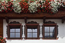 Un particolare di finestre e balcone fiorito in Alpbach, Tirolo (Austria) - Se c'è una specialità che questa città tedesca del Tirolo può vantare in modo magistrale, ...