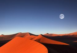 La Luna piena sorge al tramonto del sole sulle coloratissime dune di sabbia di Sossusvlei in Namibia - © Dietmar Temps / Shutterstock.com