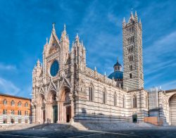La spledida Cattedrale di Siena, dedicata a Santa Maria Assunta, fotografata al mattino presto con un cielo terso alle spalle. La facciata è riccamente decorata, realizzata in marmo bianco ...