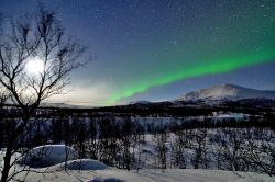 Luna con aurora Boreale nel Lappland: ci troviamo vicino ad Abisko in Svezia, località famosa per ospitare l'Aurora Sky Station, all'interno del Parco Nazionale.