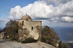 Erice, Trapani, Sicilia: la piccola chiesa in sasso dedicata a San Giovanni Battista se ne sta appollaiata sul monte Erice in posizione panoramica, come una vedetta con gli occhi rivolti ...