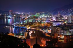 Skyline della baia di Nagasaki (Giappone) in versione notturna, con migliaia di luci colorate che si specchiano nell'acqua - © SeanPavonePhoto / Shutterstock.com