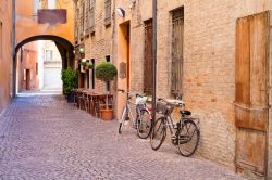 Centro storico di Ferrara, Emilia Romagna: una delle tipiche strade medievali, con ciottoli, archi e mattoni a vista. La bicicletta è il mezzo ideale per scoprire questa città ...