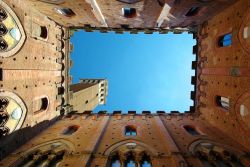La Torre del Mangia fotografata dall'interno del Palazzo Pubblico (o Palazzo Comunale) di Siena, Toscana. La torre di 88 metri è tra le più alte d'Italia e contiene un ...
