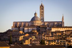 Siena, Toscana: la luce del tramonto accarezza il Duomo, la sua grande cupola e il suo campanile. L'edificio, situato nell'omonima piazza, è un notevole esempio di architettura ...