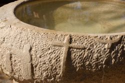 Un'acquasantiera in pietra all'interno di una delle chiese di Betania oltre il Giordano, il sito archeologico identificato come il luogo del Battesimo di Gesù, in Giordania - Marco ...