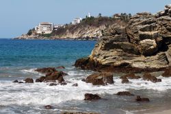 Alberghi e faro sulla costa rocciosa di Puerto Escondido, Messico.



