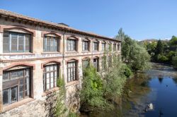 Un'antica fabbrica affacciata lungo il corso del fiume Fluvia a Olot, Spagna - © joan_bautista / Shutterstock.com