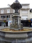 Antica fontana in pietra in Place du Marcadal a Lourdes, Francia. Sullo sfondo la facciata di edifici - © Dan Shachar / Shutterstock.com