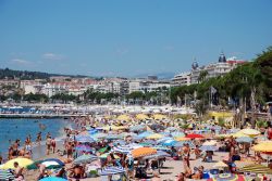 Bagnanti sulla spiaggia di Cannes, Costa Azzurra, Francia. Si estende per circa 9 chilometri e nei mesi estivi è frequentata da residenti, turisti e anche personaggi famosi del mondo ...