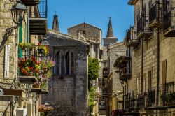 Balconi fioriti nelle stradine medievali di Petralia Soprana, provincia di Palermo, Sicilia. Sullo sfondo, le guglie della chiesa di Santa Maria.

