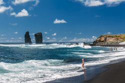 Una bambina con i piedi nell'acqua sulla spiaggia di Mosteiros a Ponta Delgada, isola di Sao Miguel (Portogallo) - © 294493358 / Shutterstock.com