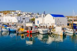 Barche colorate al porto di Naoussa, Grecia. Case bianche, strette viuzze lastricate, archi e chiese, oltre a spiagge rinomate, attirano soprattutto d'estate molti visitatori in questo villaggio ...