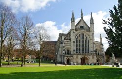 Una bella veduta panoramica della cattedrale di Winchester, Inghilterra. La facciata è caratterizzata dalla forma slanciata tipica del gotico, da un finto portico e da una enorme vetrata.
 ...