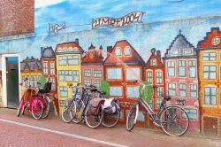 Biciclette parcheggiate lungo le mura dipinte delle tradizionali case olandesi a Leeuwarden, Paesi Bassi - © ingehogenbijl / Shutterstock.com
