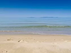 Cala Violina, Scarlino, considerata la spiaggia migliore della Toscana, sullo sfondo l'Isola d'Elba