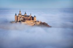 Castello di Hohenzollern sopra le nuvole, Sigmaringen, Germania -  Un'immagine quasi fiabesca del castello cittadino fotografato dall'alto e racchiuso fra le nubi. Grazie alla roccia ...