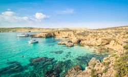 Acque cristalline a Comino, Malta - Rinomata per il suo mare trasparente di un profondo colore turchese, Comino ha una ricca fauna marina che la rende fra i luoghi più popolari per le ...