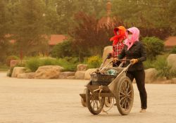 Due donne camminano per strada durante una tepesta di sabbia a Yinchuan, Cina.



