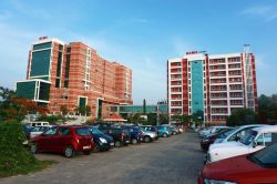 Due edifici del Kerala Institute of Medical Sciences (KIMS) di Trivandrum, India. Veduta panoramica dal parcheggio delle automobili - © AjayTvm / Shutterstock.com