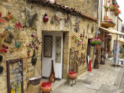 La facciata di un negozio di souvenir nel centro cittadino di Domme, Dordogna, Francia. A decorarne l'esterno sono oggetti in ceramica dai mille colori, solo alcuni di quelli qui in vendita ...