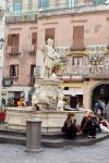 Fontana in una piazza di Amalfi con persone sedute sugli scalini, Campania. Sullo sfondo, negozi di souvenir e botteghe - © Angela N Perryman / Shutterstock.com