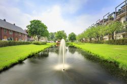 Fontana in uno stagno nei pressi di case residenziali a Zoetermeer, Olanda, nel quartiere di Het Dorp.

