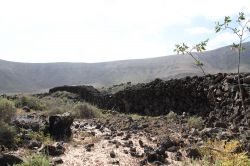 La natura incontaminata del villaggio preistorico di Fuerteventura (Spagna) - In moltissime zone appartenenti al villaggio preistorico di Fuerteventura il terreno si presenta rossiccio, arido ...