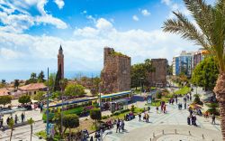 Gente a passeggio nel centro storico di Antalya, Turchia: la Torre dell'Orologio, la Tekeli Mehmet Pasa Mosque e la Yivli Minare Mosque (nota anche come Moschea di Aladino) - © Igor ...