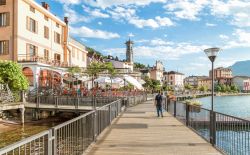 Gente in relax e a passeggio sul lungolago di Porto Ceresio, graziosa città del lago di Lugano - © elesi / Shutterstock.com