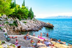 Gente nuota e prende il sole sulla costa rocciosa di Trpanj, nel sud della Croazia - © nomadFra / Shutterstock.com