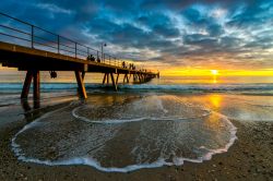 Gente passeggia al tramonto sul molo di Glenelg Beach, Adelaide (Australia).

