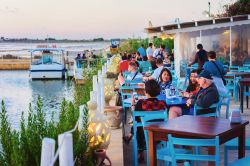 Gente seduta in un caffé sulla strada in una salina di Marsala, Sicilia - © Roman Babakin / Shutterstock.com