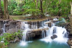 Giochi d'acqua nelle cascate di Huay Mae Kamin nello Srinakarin Dam National Park, Kanchanaburi, Thailandia: considerata una delle più belle cascate della Thailandia, si separa e ...