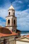 Il campanile di una chiesa nei pressi del villaggio di Santa Maria di Castellabate, Campania, Italia. L'azzurro del cielo e del mare fanno da cornice a questa costruzione religiosa che sorge ...