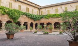 Il chiostro della Basilica di San Nicola a Tolentino, Marche. A impreziosirne l'architettura vi sono fiori e piante - © Vincenzo De Bernardo / Shutterstock.com