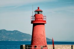 Il faro rosso del porto dell'isola del GIglio, il punto di arrivo dei traghetti dall'Argentario - © maurizio / Shutterstock.com