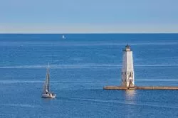 Il faro sul lago Michigan nei pressi di Frankfort, Stati Uniti d'America, con una barca a vela. Siamo su una scogliera a sud della città. 

