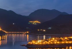 Il lago di Turano nel Lazio con le luci di Castel di Tora e, sullo sfondo, il borgo illuminato di Ascrea. Situato in provincia di Rieti, Ascrea è un centro agricolo della Sabina, nella ...