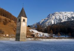 Il lago Resia in inverno e il campanile del villaggio abbandonato di Curon Vecchia in Trentino