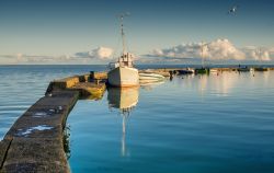 Il molo in pietra con le barche ormeggiate alla marina di Curonian Spit, Nida, Lituania - © Sergei25 / Shutterstock.com